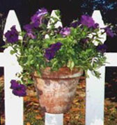 Install Hang-A-Pot to hang flowers on a picket fence