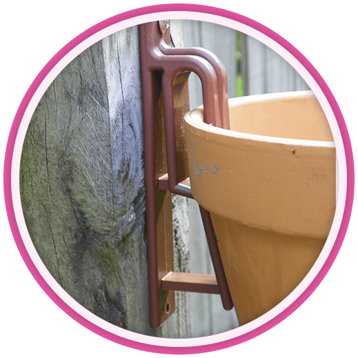 Close up side view shot of hangapot clay pot hanger attched to a fence post with a 9 inch clay pot suspended from the hanger